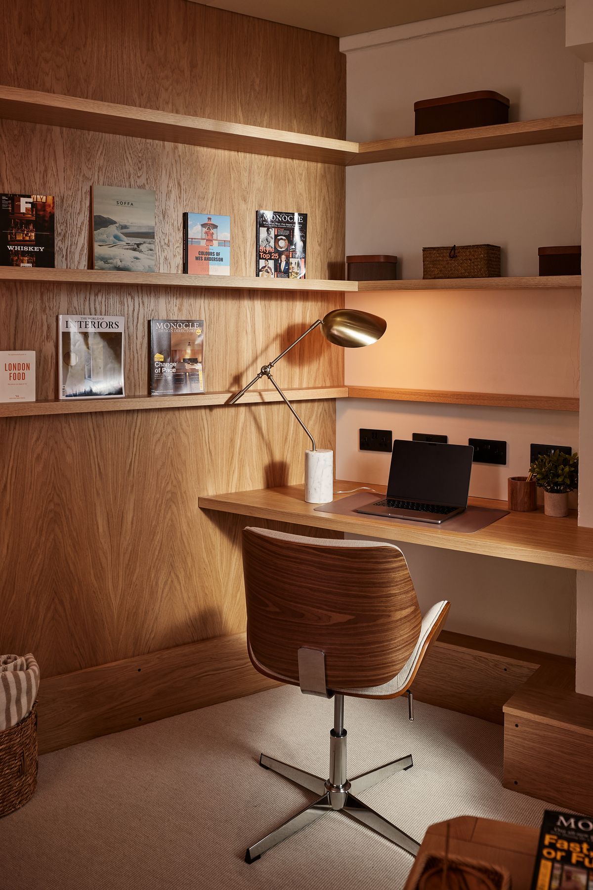 Writing desk in an oak-panelled nook with brass lamp