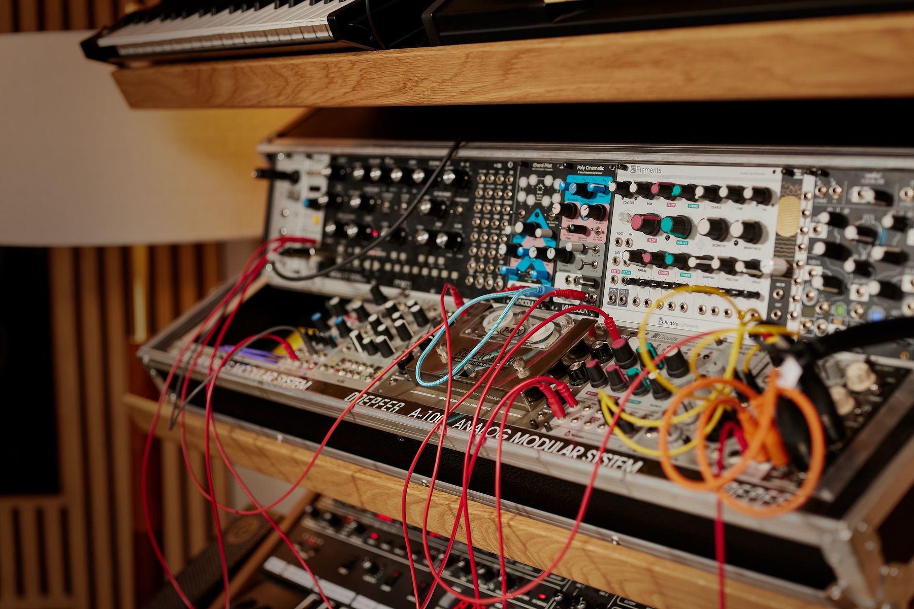 Patched modular synthesizer with red and orange cables