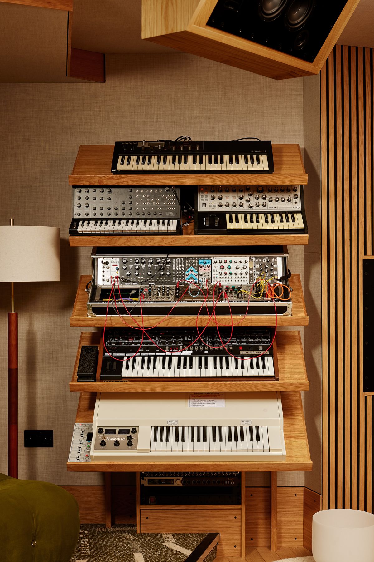 Waldorf, Korg, Moog, Prophet and Mellotron keyboards on oak shelves